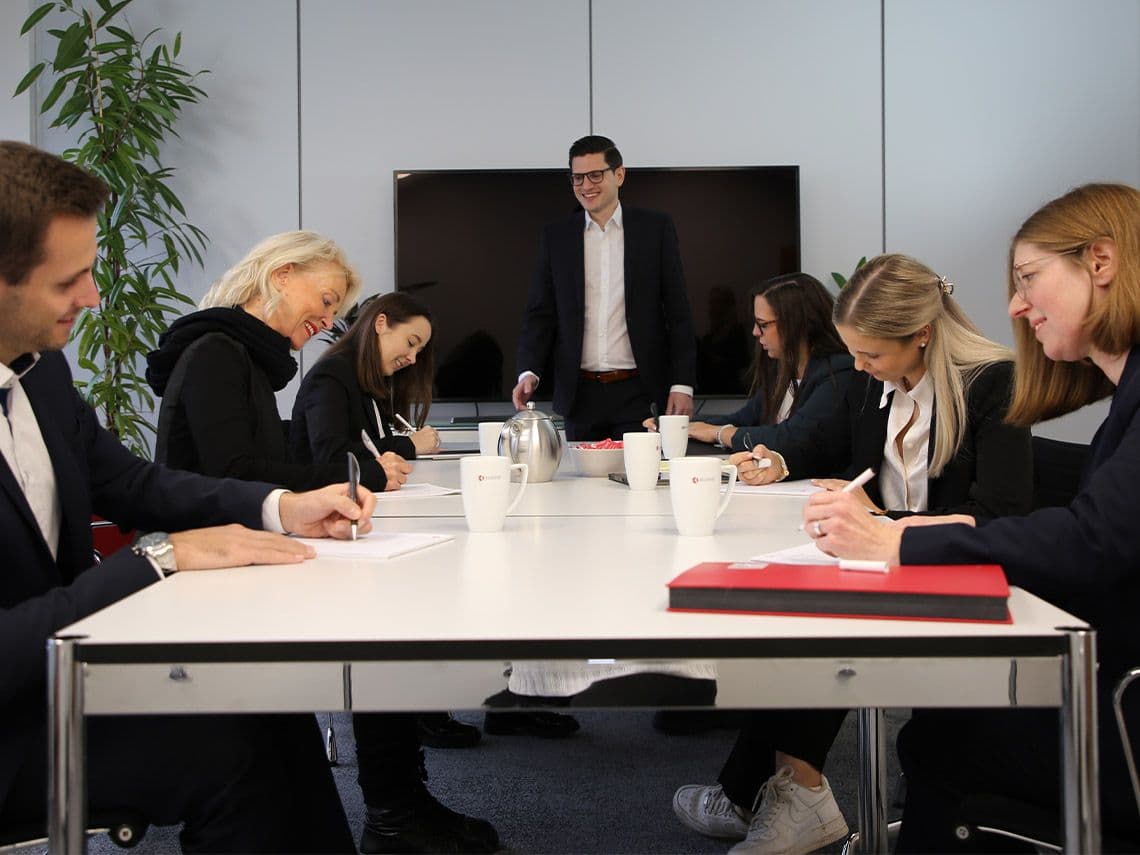 Mehr-über-das-Unternehmen ECOVIS KSO Gruppe am Schreibtisch in Besprechung